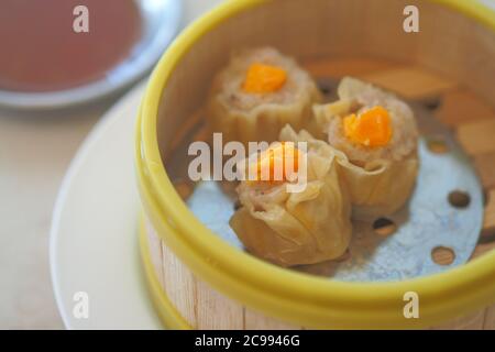 Granchio cinese cotto a vapore Dumpling con uovo salato in bambù vaporiera Cestino - cucina cinese menu Dimsum Foto Stock