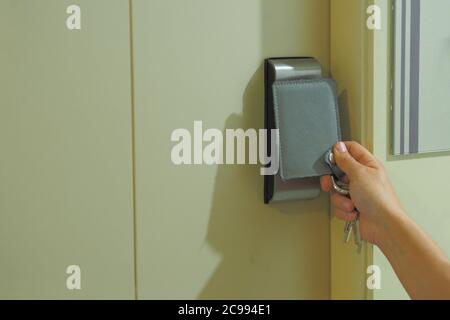 Le donne stanno usando una carta chiave per aprire la porta per entrare nella stanza nel condominio. Sicurezza - sistemi di accesso KeyCard Foto Stock