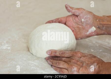 mani da donna impastate per preparare l'impasto per gnocchi. Foto Stock