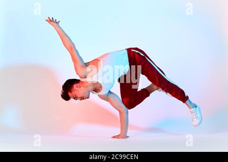 Hip-hop coreano break ballerino in pantaloni rosso sudore rimanere in classe bianca tutto il giorno e imparare coreografia fatto da altre persone, allenarsi sulla tecnica Foto Stock