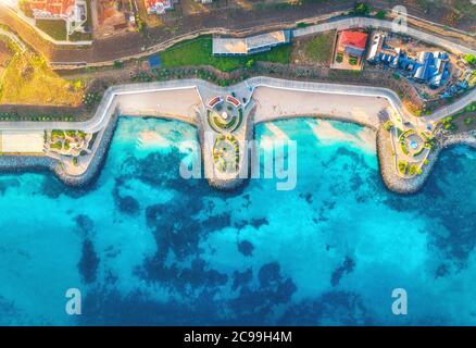 Vista aerea della spiaggia di sabbia, mare blu, ristoranti al tramonto Foto Stock