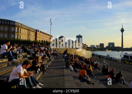 Gradini della terrazza sul Reno (in tedesco: Rheintrepe) sul fiume Reno è il ‚posto per essere‘ per i turisti e la gente del posto in una giornata calda. Uno dei luoghi più popolari della città. Foto Stock