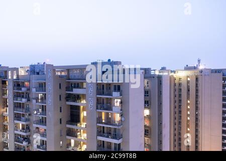 Crepuscolo aereo di bouldings con calde luci arancioni che brillano fuori degli uffici e delle residenze di recente costruzione Foto Stock