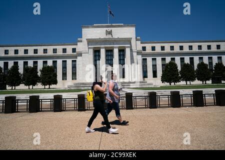 Washington, Stati Uniti. 29 luglio 2020. La gente cammina oltre l'edificio della Federal Reserve degli Stati Uniti a Washington, DC, Stati Uniti, 29 luglio 2020. La Federal Reserve degli Stati Uniti il mercoledì ha mantenuto il suo tasso di interesse di riferimento invariato al livello record-basso di quasi zero in una recente ripresa in COVID-19 casi a livello nazionale. Credit: Liu Jie/Xinhua/Alamy Live News Foto Stock