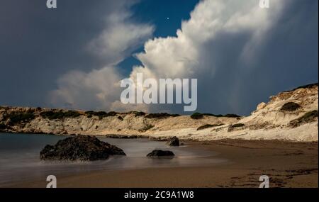 Spiaggia di sabbia e ciottoli del Mar Mediterraneo, fucilata in condizioni meteorologiche calme di notte con una lunga esposizione. Foto Stock