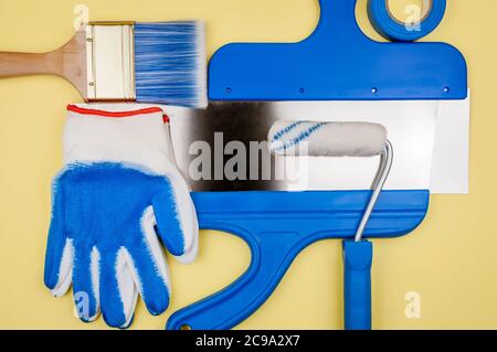 Attrezzo di costruzione su uno sfondo giallo. L'attrezzo del pittore. Foto Stock