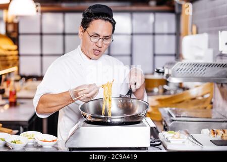 chef eserieriato che fa del suo meglio in cucina. primo piano foto. Foto Stock