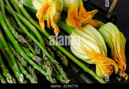 Primo piano di asparagi e zucchine con fiori. Concetto di alimentazione sana. Foto Stock