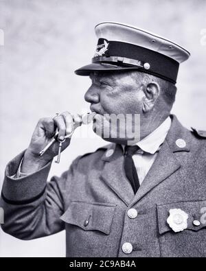 1920 1930 POLIZIOTTO DEL TRAFFICO CHE SOFFIA FISCHIO CHE INDOSSA UNIFORME - C3155 HAR001 HARS MASCHI RISK ORDER OFFICER DI MEZZA ETÀ B&W UOMO DI MEZZA ETÀ COP ABILITÀ OCCUPAZIONE PROTEGGERE LE COMPETENZE PROTEZIONE ED ECCITAZIONE AVVERTIMENTO LAVORO AUTORITÀ OCCUPAZIONE OCCUPAZIONI UNIFORMI ALLERTAMENTO FUNZIONARI DEI DIPENDENTI POLIZIOTTI BADGE BADGE NERO E BIANCO CAUCASICO ETNIA HAR001 LABORING VECCHIO STILE Foto Stock