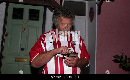 Londra, 29 luglio 2020 - UK UN sostenitore controlla nervosamente il suo telefono prima del fischio finale. Tifosi al Brentford Football Club, l'ultima notte di calcio nella loro casa storica (dal 1904) prima di trasferirsi al loro nuovo terreno, il Brentford Community Stadium. Hanno vinto la semifinale del playoff per raggiungere la finale Andrew Fosker / Alamy News Live Foto Stock