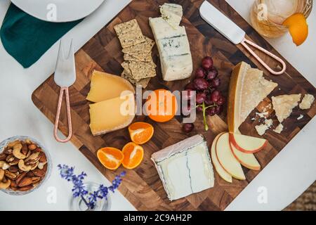 Formaggio a tavola con formaggi assortiti, cracker e frutta Foto Stock