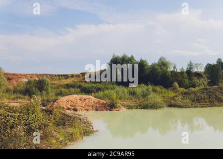 Open buca lago di cava di amianto con acqua blu. Foto Stock