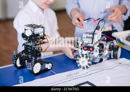 Giovani tecnici del team lavorando sul giocattolo. Giocattolo tecnico sul tavolo pieno di dettagli. istruzione technopogy scienza ai bambini il concetto di creatività Foto Stock