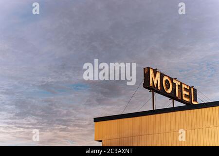 Motel neon segno su un tramonto cielo nuvoloso Foto Stock