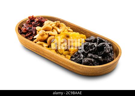 Vari frutti secchi in un vassoio di legno su sfondo bianco con percorso di ritaglio. Foto Stock