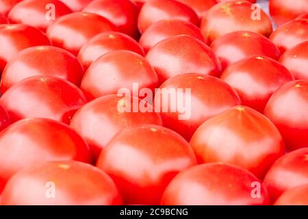 Solido sfondo di pomodori freschi maturi e rossi naturali Foto Stock