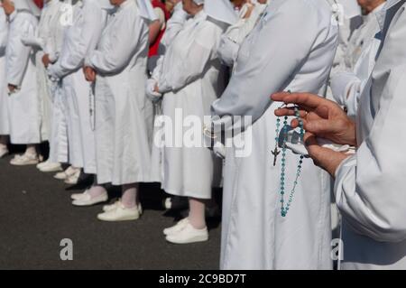 Primo piano di mani mans che tengono rosario perline e croce mentre pregano, Irlanda Foto Stock