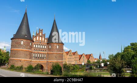 Lübeck, Schleswig-Holstein - 22 giugno 2020: Panorama con Holstentor e gli storici edifici Salzspeicher (deposito di sale). formato 16x9, cielo blu. Foto Stock