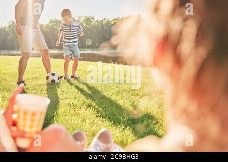 Padre e figlio trascorrono del tempo a giocare a calcio in campeggio Foto Stock