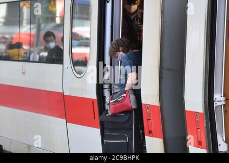 Obbligo di mascheramento nei trasporti pubblici. Stazione centrale di Monaco il 29 luglio 2020. I passeggeri scpartono con maschere facciali, maschere dopo l'arrivo di un treno dal carro, carro. Protezione bocca-naso.protezione mun, maschera, maschere, OEPNV, trasporto pubblico, trasporto a lunga distanza, | utilizzo in tutto il mondo Foto Stock