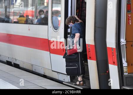 Obbligo di mascheramento nei trasporti pubblici. Stazione centrale di Monaco il 29 luglio 2020. I passeggeri scpartono con maschere facciali, maschere dopo l'arrivo di un treno dal carro, carro. Protezione bocca-naso.protezione mun, maschera, maschere, OEPNV, trasporto pubblico, trasporto a lunga distanza, | utilizzo in tutto il mondo Foto Stock