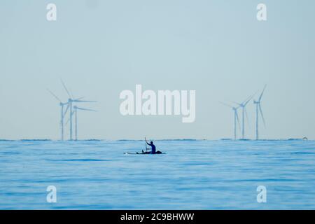 Worthing Beach, Worthing, Regno Unito. 30 luglio 2020. I paddleboarders godono del mare tranquillo del mattino. Con un cielo blu chiaro e acque piatte, le persone su tavole da paddle godersi la mattina presto al largo della costa del sussex. Rampion Wind Farm può essere visto 13-20km offshore. Foto per credito: Julie Edwards/Alamy Live News Foto Stock