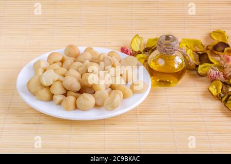 Ciotola di olio di noci e noci di macadamia, concetto di cibo sano Foto Stock