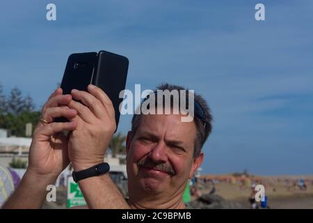 L'uomo nei primi anni fa selfie vicino ad una spiaggia Foto Stock