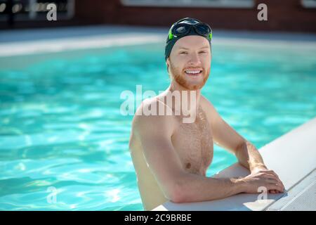 Giovane adulto in berretto da bagno in piscina Foto Stock