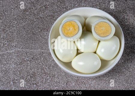 Uova sbucciate bollite senza guscio su sfondo grigio. Ingredienti per cucinare. Foto Stock