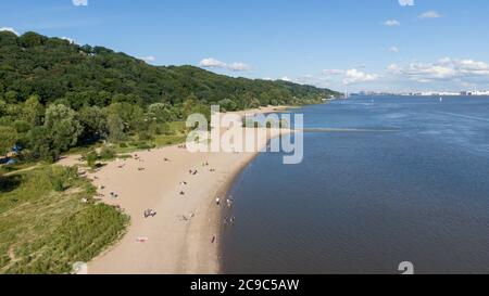 Amburgo, Germania. 11 Luglio 2020. La gente sta camminando o sdraiandosi sulla spiaggia dell'Elba vicino al Falkensteiner Ufer (vista aerea con un drone). Sullo sfondo si può vedere il sito della fabbrica Airbus e il porto di Amburgo. Credit: Jonas Walzberg/dpa/Alamy Live News Foto Stock