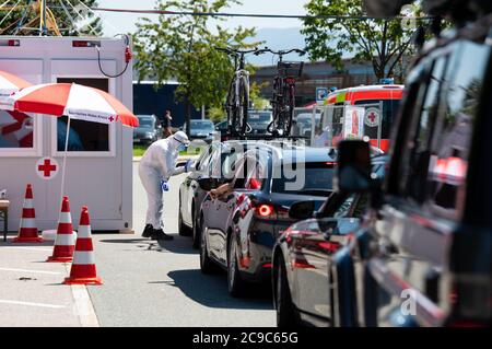 Bergen, Germania. 30 luglio 2020. I dipendenti della Croce Rossa Bavarese si sottoponano a un test di sbavatura presso un centro di prova corona sull'autostrada 8 (A8) nella zona di sosta di Hochfelln-Nord. In considerazione del recente aumento delle cifre relative all'infezione da corona, il governo dello Stato bavarese sta lanciando un'offensiva contro l'incuria e sta lanciando un'offensiva di prova. Le persone che ritornano da un viaggio possono avere essi stessi testato per il virus corona a varie fermate di riposo gratuitamente. Credit: Sven Hoppe/dpa/Alamy Live News Foto Stock