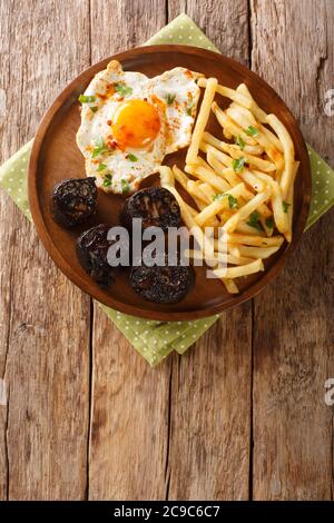 Huevos Rotos Con Uovo Fritto Di Morcilla Con Patatine Fritte E Salsiccia Di Sangue Primo Piano In Un Piatto Sul Tavolo Vista Dall Alto Verticale Foto Stock Alamy