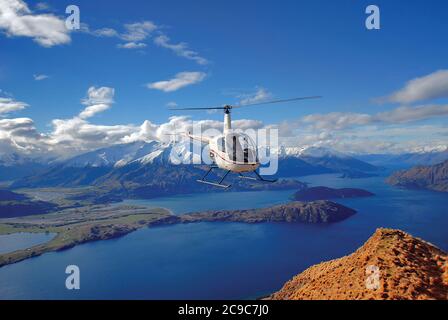 Un elicottero Robinson R22 Beta sul lago Wanaka e l'area dei laghi meridionali della Nuova Zelanda. Foto Stock