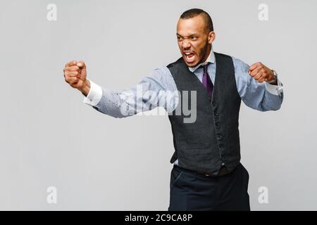 Arrabbiato arrabbiato giovane uomo lavoratore ufficio, dipendente aziendale, pugni in aria, bocca aperta urlare e gridare, emozione negativa sensazione di espressione facciale Foto Stock