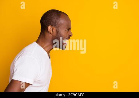 Primo piano profilo vista laterale ritratto del suo ha devastato pazzo furia pazzo male selvaggio ragazzo che esprime rabbia isolato su luminoso giallo brillante e brillante Foto Stock