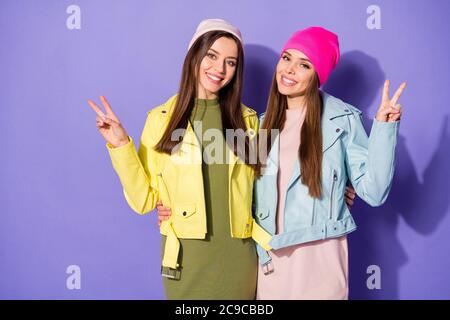 Ritratto di belle-osservanti belle belle belle belle ragazze allegre graziose allegre con segno v isolato su lilla violetta brillante e brillante Foto Stock