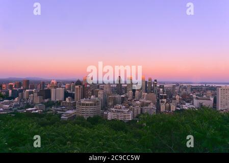 Una vista aerea dello skyline di una città grattacieli, edifici, e strade, presi da una montagna al tramonto, Montreal, QC, Canada Foto Stock