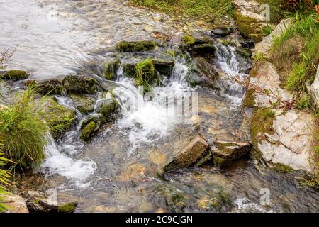 St Nectans Glen - acqua che scorre su pietre in Cornovaglia Foto Stock