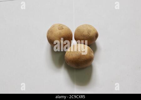 Tre patate fresche . Patate fresche su fondo bianco. Vista dall'alto Foto Stock