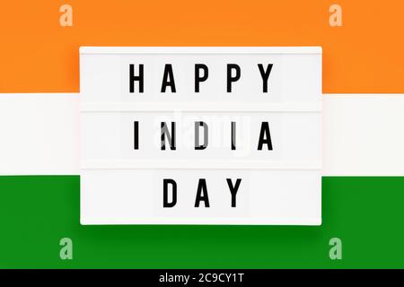 HAPPY INDIA GIORNO scritto in un lightbox su uno sfondo di colore della bandiera indiana. Data del giorno dell'indipendenza. Vista dall'alto. Foto Stock