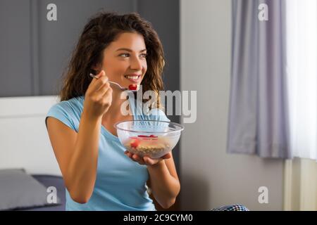 Bella donna ama mangiare cereali per la prima colazione. Foto Stock