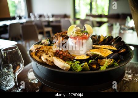 Piatto di pesce per 2-4 persone. Polpo, cozze blu, cozze verdi cotte, gamberi di tigre alla griglia, tartare di tonno. Deliziosi crostate di pesce serviti su Foto Stock