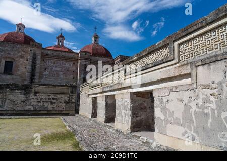 Pannelli in pietra sulle pareti del cortile B, (Quadrangle B), nelle rovine della città Zapotec di Mitla, vicino a Oaxaca, Messico. Dietro c'è la Coira Foto Stock