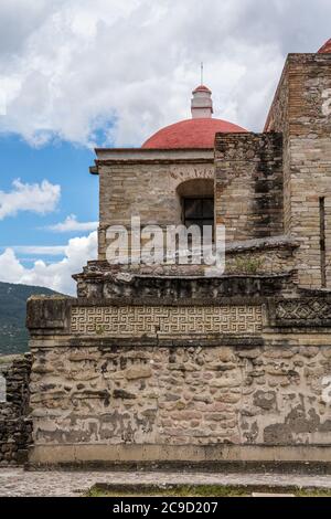 Pannelli in pietra sulle pareti del cortile B, (Quadrangle B), nelle rovine della città Zapotec di Mitla, vicino a Oaxaca, Messico. Dietro c'è la Coira Foto Stock