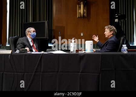 Il senatore degli Stati Uniti Jeff Merkley (democratico dell'Oregon) parla al senatore americano Rand Paul (repubblicano del Kentucky) durante la pausa in un'audizione del Comitato per le relazioni esterne del Senato giovedì 30 luglio 2020 per discutere la richiesta di bilancio FY 2021 dell'amministrazione Trump per il Dipartimento di Stato.Credit: Greg Nash/Pool via CNP | utilizzo in tutto il mondo Foto Stock