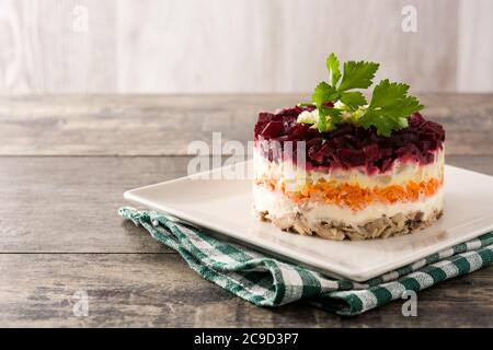 Insalata tradizionale russa di aringhe con barbabietole e carote su tavolo di legno Foto Stock