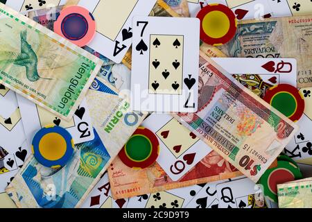 Carte mazzo sul tavolo del casinò con gettoni e denaro da diversi paesi Foto Stock