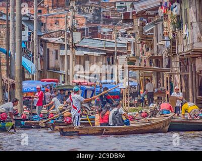 Belen, Perù - dicembre 2019: Persone sulle barche tra case galleggianti nella pianura alluvionale del fiume Itaya, la parte più povera di Iquitos - Belén. Venezia di la Foto Stock