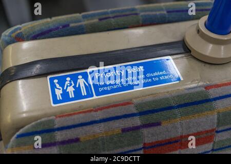 Segnale di posto prioritario per anziani o disabili su un posto a sedere in treno. Londra Foto Stock